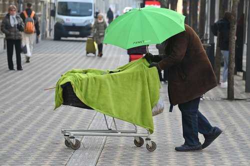 Slovenija, Ljubljana, 11.01.2024, 11. januar 2024Moški z vozičkom in zelenim dežnikom na slovenski cesti. Pločnik, brezdomci, ljudje, družba, kapitalizem, Foto: Žiga Živulović jr./Bobo *** Local Caption ***