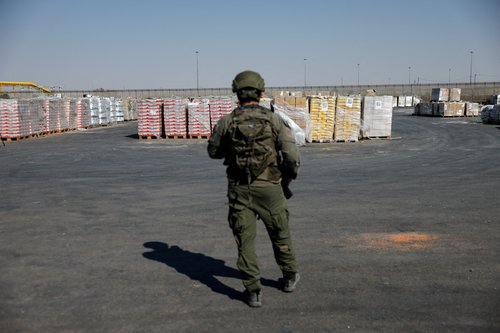 Izraelski vojak straži humanitarno pomoč za Gazo ob meji z enklavo