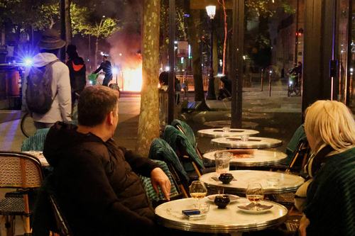 Par iz kavarne opazuje proteste v Parizu