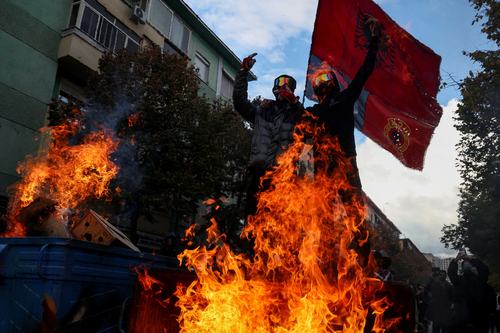 Protesters gesture next to burning barricade during an anti-government protest in Tirana, Albania, October 31, 2026. REUTERS/Florion Goga