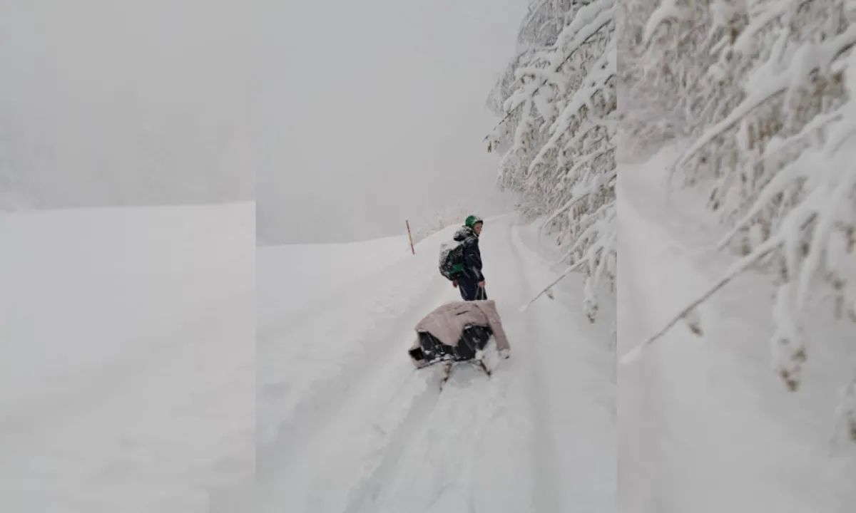 Mladi nogometaš s sankami in prtljago v dolino, da bi ujel prevoz na priprave