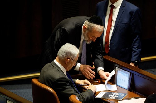 Israeli designate Prime Minister Benjamin Netanyahu signs a document during a session at the plenum at the Knesset, Israel's parliament in Jerusalem