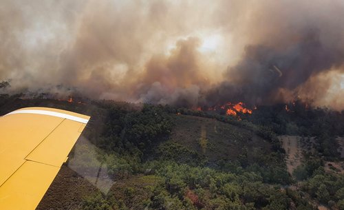 Turkish firefighting planes fly over a wildfire burning on the island of Rhodes