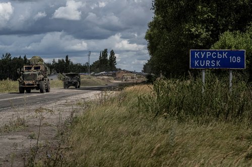 FILE PHOTO: Ukrainian servicemen ride military vehicles from a crossing point at the border with Russia in Sumy region