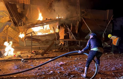 Palestinci gasijo požar po izraelskem napadu na nekdanjo šolo v Gazi.