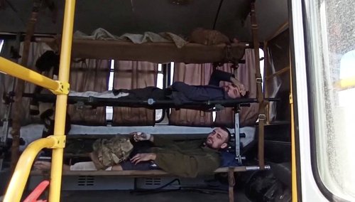 Service members of Ukrainian forces who left the besieged Azovstal steel plant are seen inside a bus in Mariupol