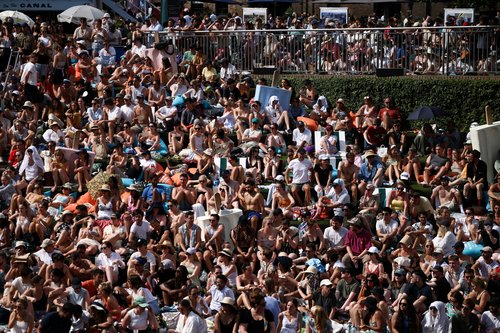 People watch the Wimbledon men’s singles final tennis match on a giant screen next to the Regent’s canal at Granary Square, during hot weather in London