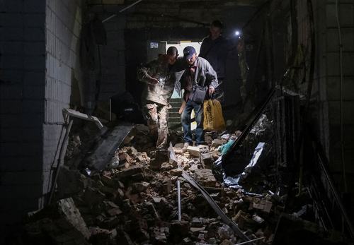 Prostovoljci rešujejo ljudi izpod ruševin po ruskem raketnem napadu na Kijev