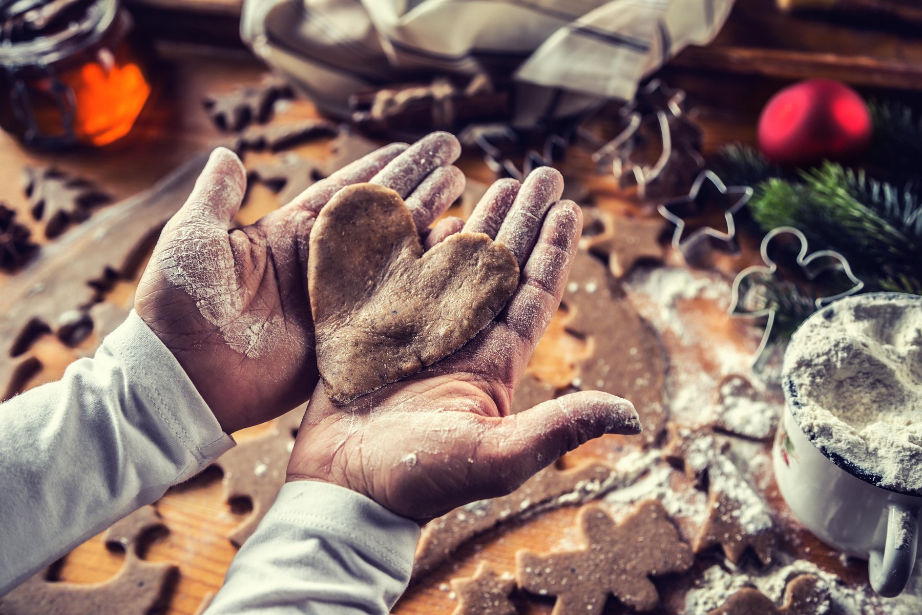 Christmas baking and gingerbread heart in woman hands.