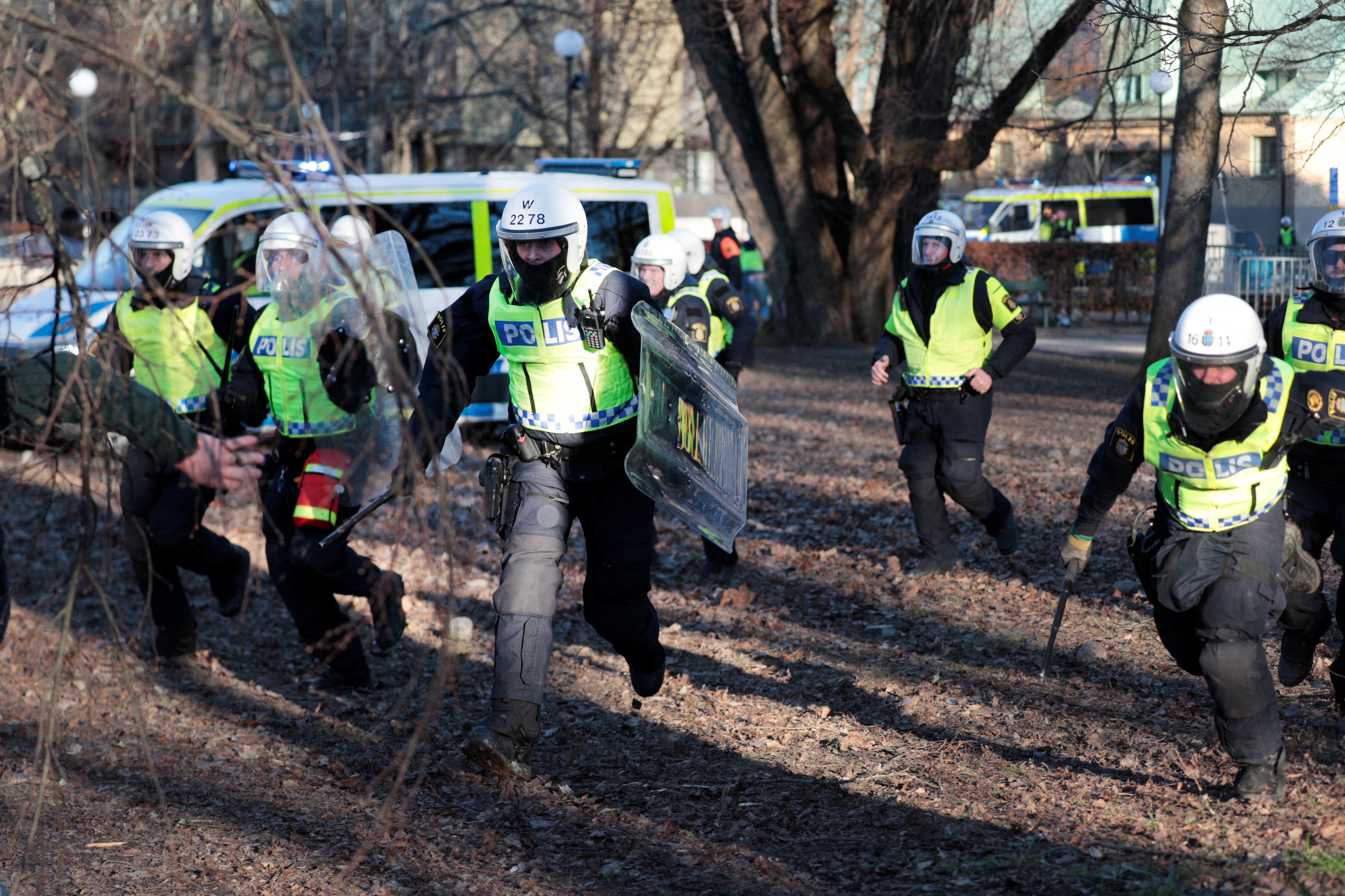 Police officers run during a protest ahead of a demonstration planned by Danish anti-Muslim politician Rasmus Paludan
