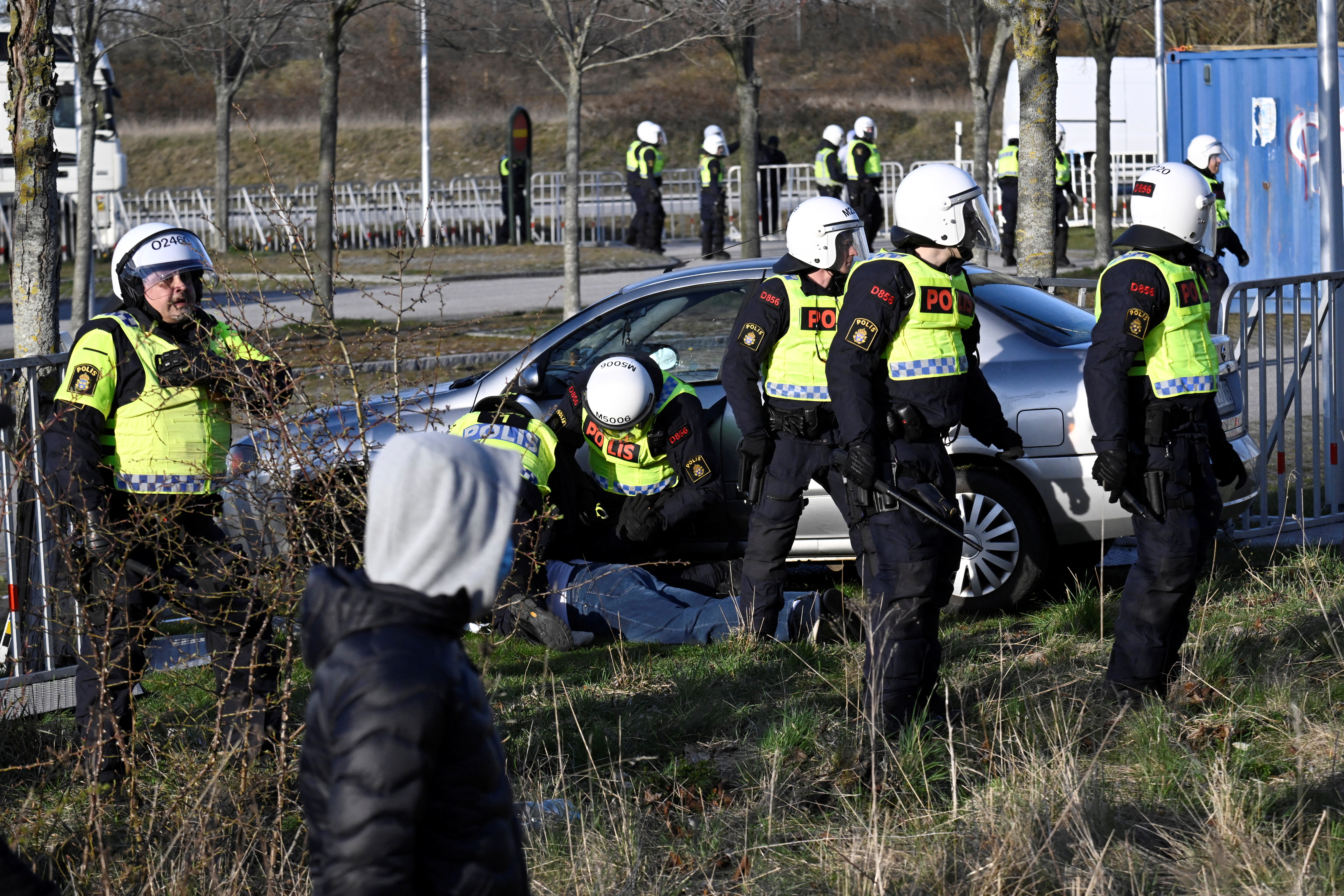 Police detain a person who drove a car into the roadblocks where Rasmus Paludan held a demonstration, in Malmo