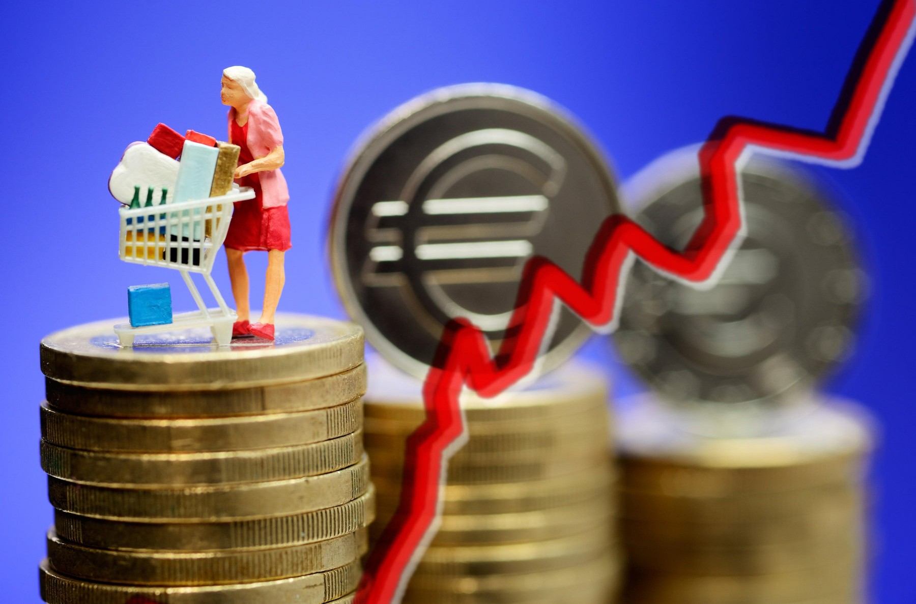 Woman by shopping cart on monetary coins, risen consumer prices, Frau mit Einkaufswagen auf Geldmuenzen, gestiegene Verbraucherpreise