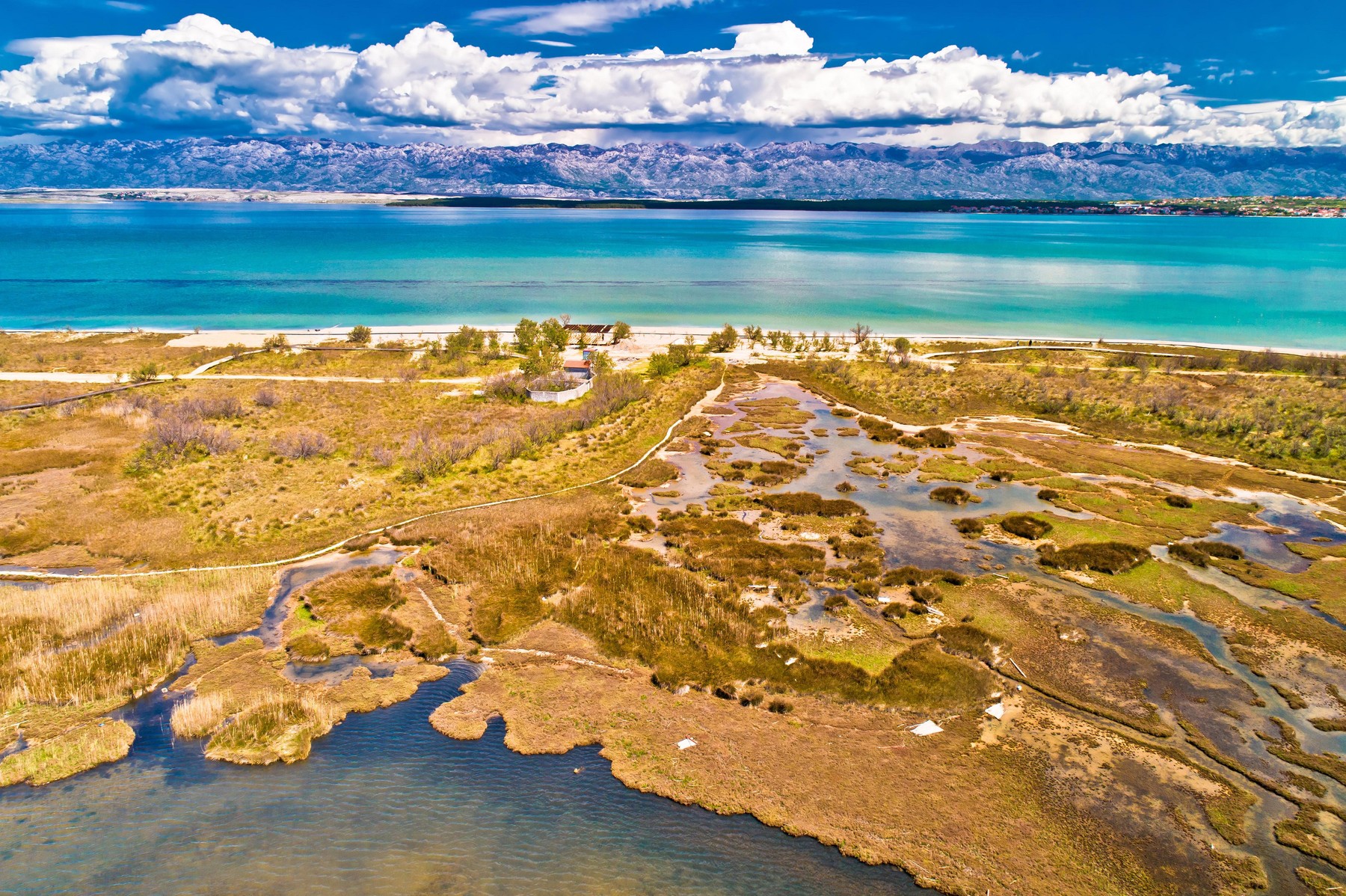 Sea marshes and shallow sand beach of Nin aerial view, Velebit mountain background, Dalmatia region of Croatia