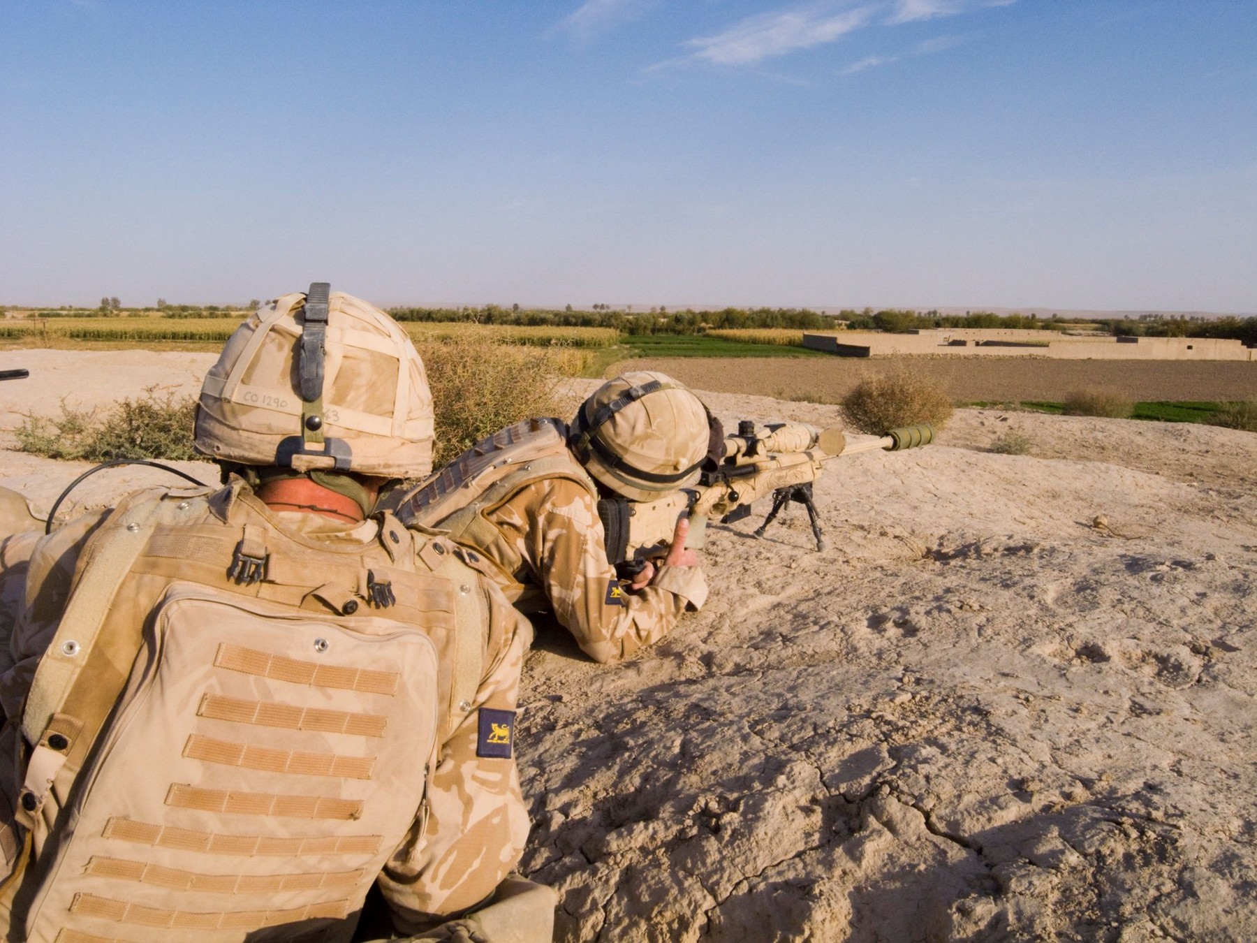 British sniper looking through sight wearing helmet and body armour Helmand Province Afghanistan