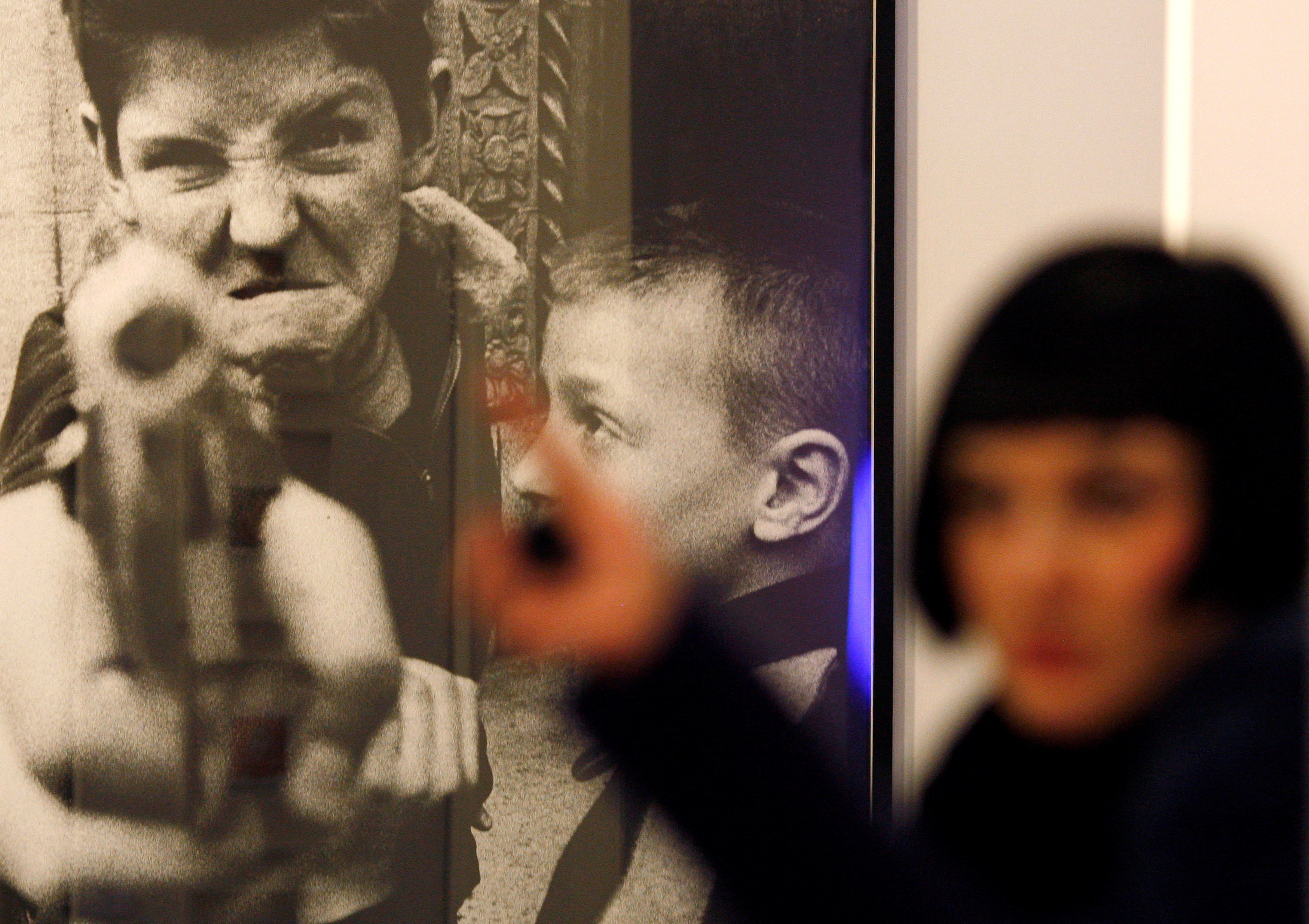 FILE PHOTO: A visitor walks past "Gun 1" by William Klein at the London Art Fair