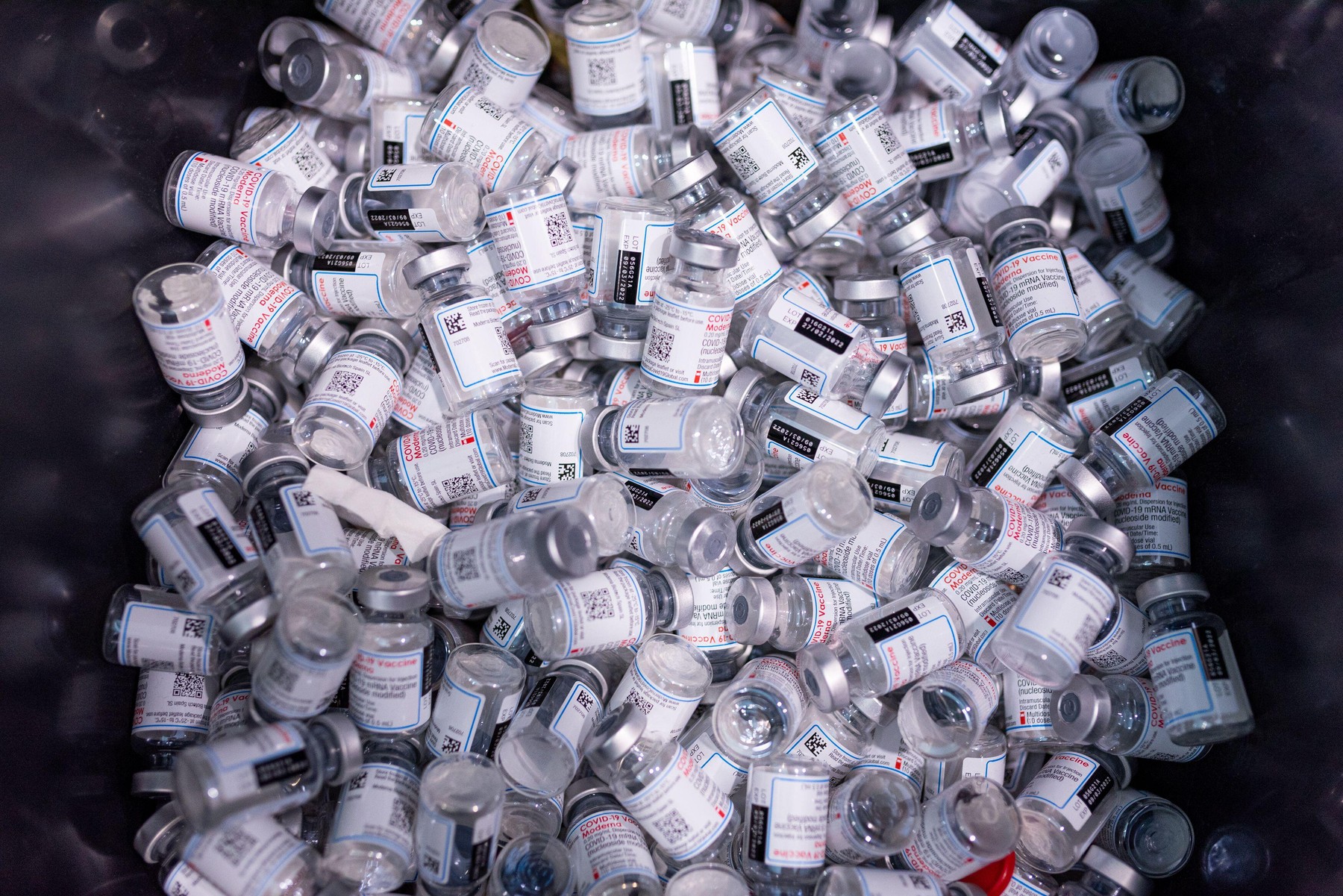 Empty vials of Moderna vaccines are seen in a trash bin at a vaccination center in Barcelona, Spain on December 22, 2021. As countries push for mass v
