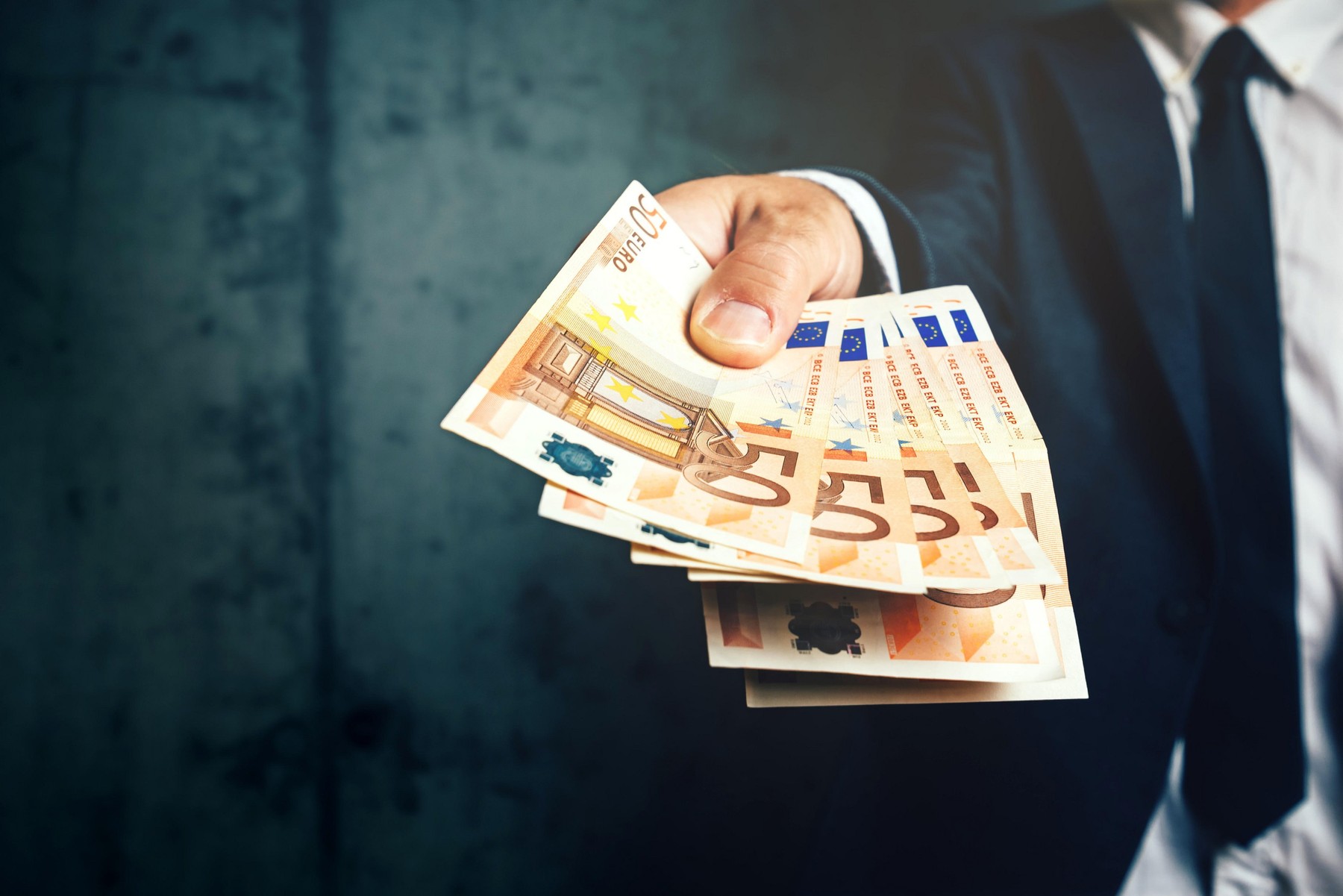 Businessman from bank offering money loan in euro banknotes, selective focus.