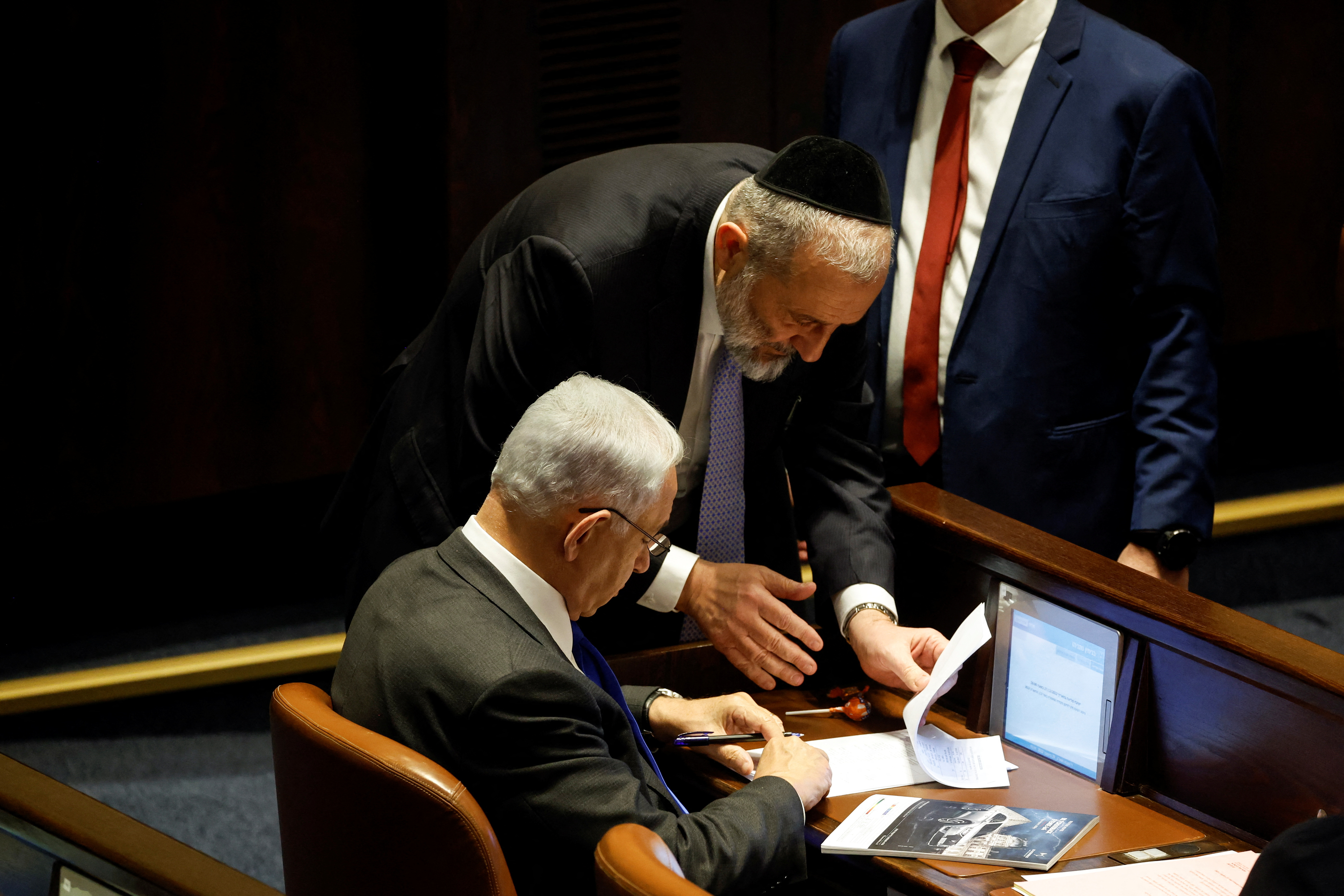 Israeli designate Prime Minister Benjamin Netanyahu signs a document during a session at the plenum at the Knesset, Israel's parliament in Jerusalem