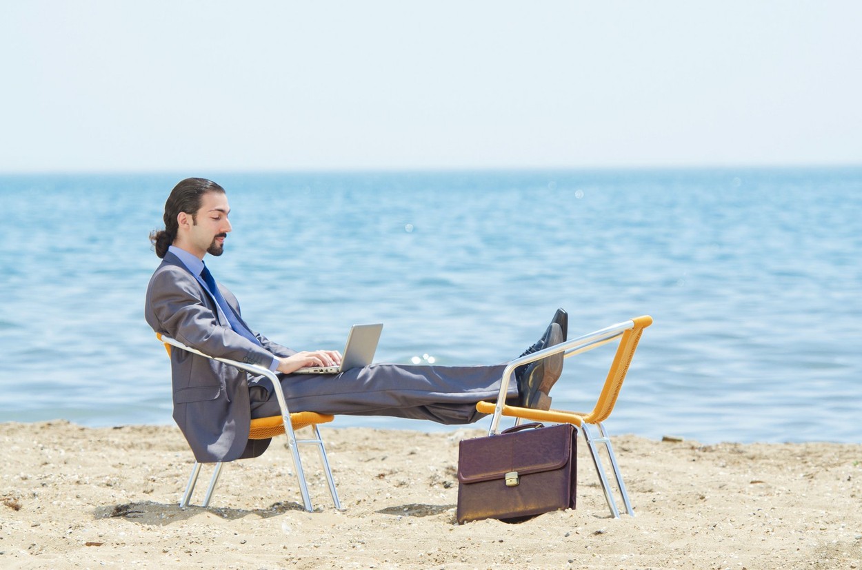 Businessman working on laptop on seaside