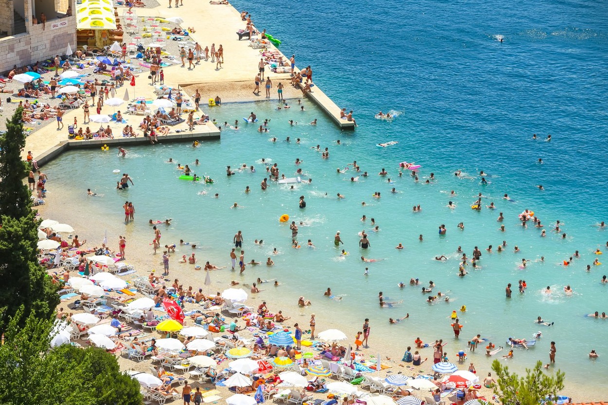 NEUM, BOSNIA AND HERZEGOVINA - JULY 16, 2017 : A view of the town waterfront and people swimming and sunbathing on the beach in Neum, Bosnia and Herze