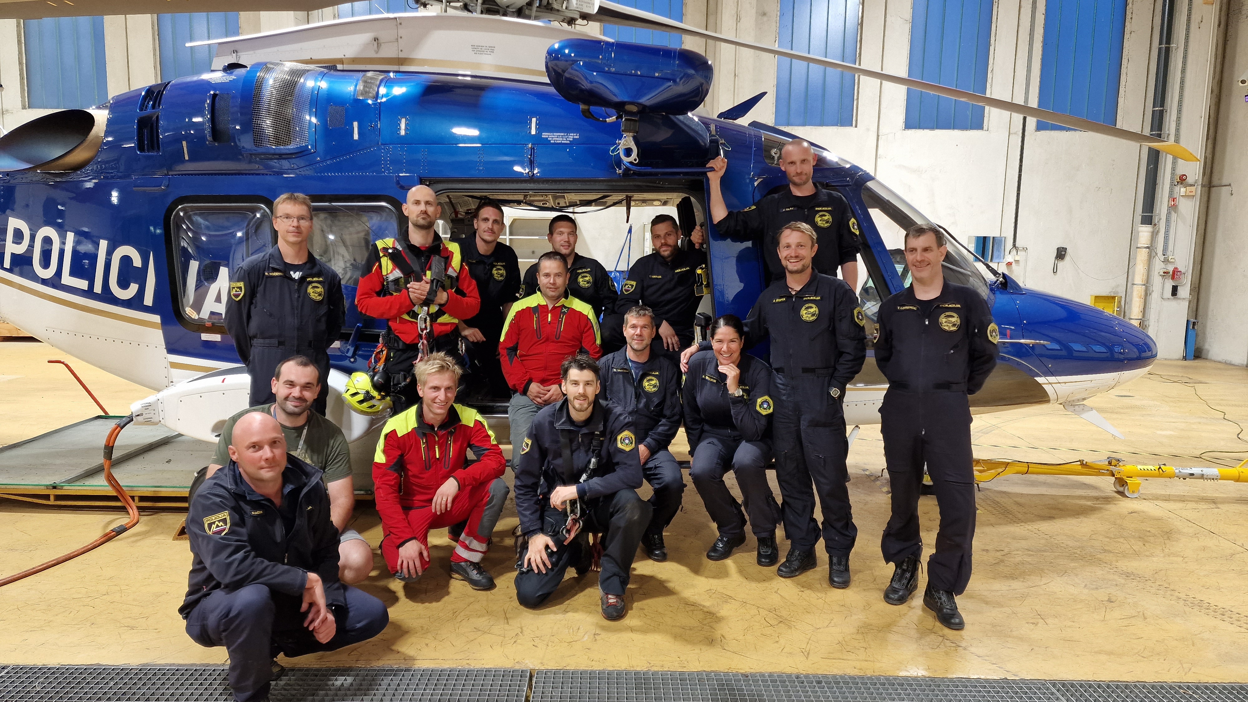 Letalska policijska enota v hangarju ob helikopterju.