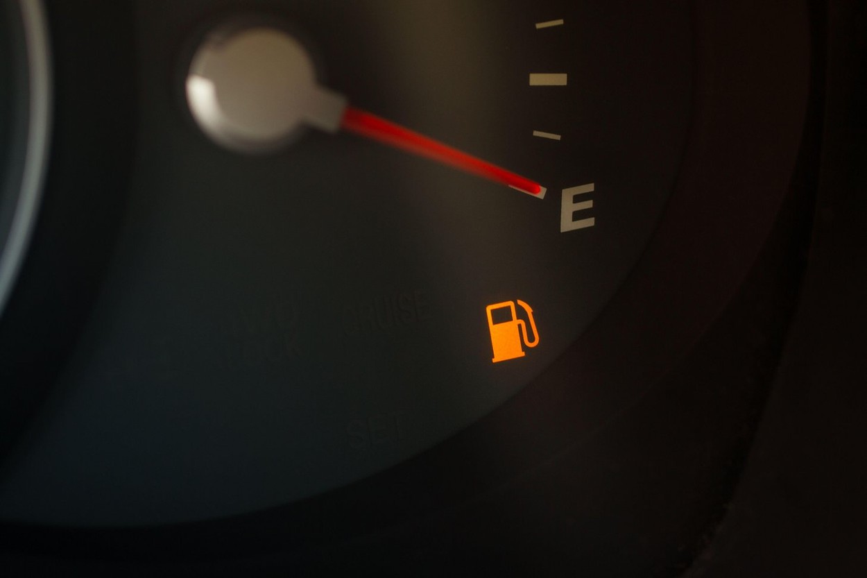 Empty fuel gauge warning light in car dashboard close up view. Fuel indicator at empty position.