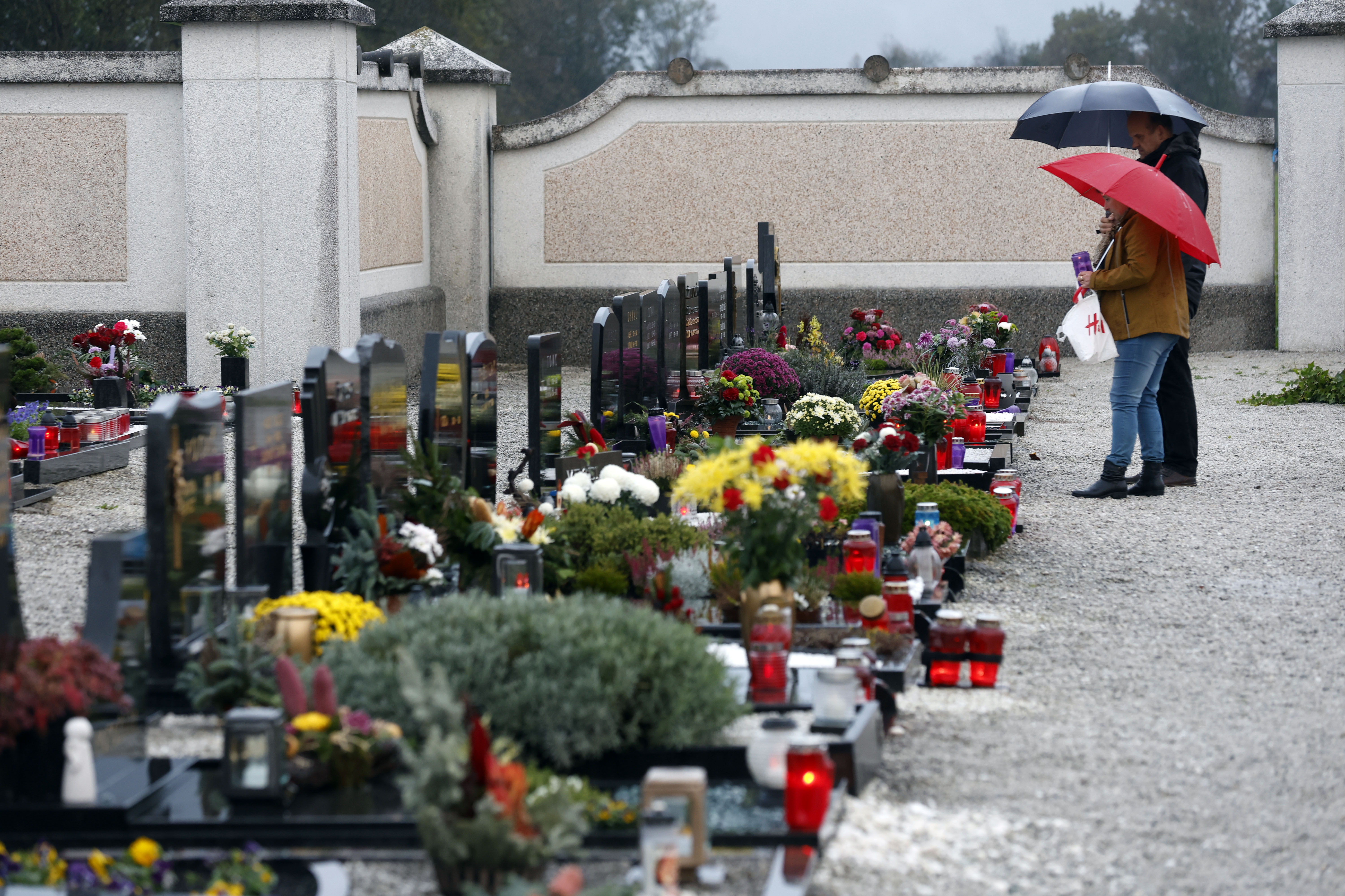 Ljudje prižigajo sveče na predvečer Dneva spomina na mrtve