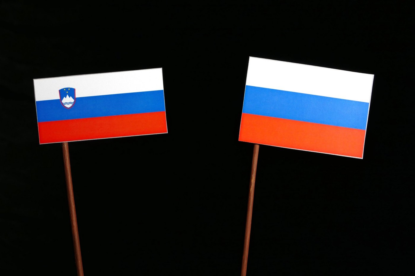 Slovenian flag with Russian flag isolated on black background