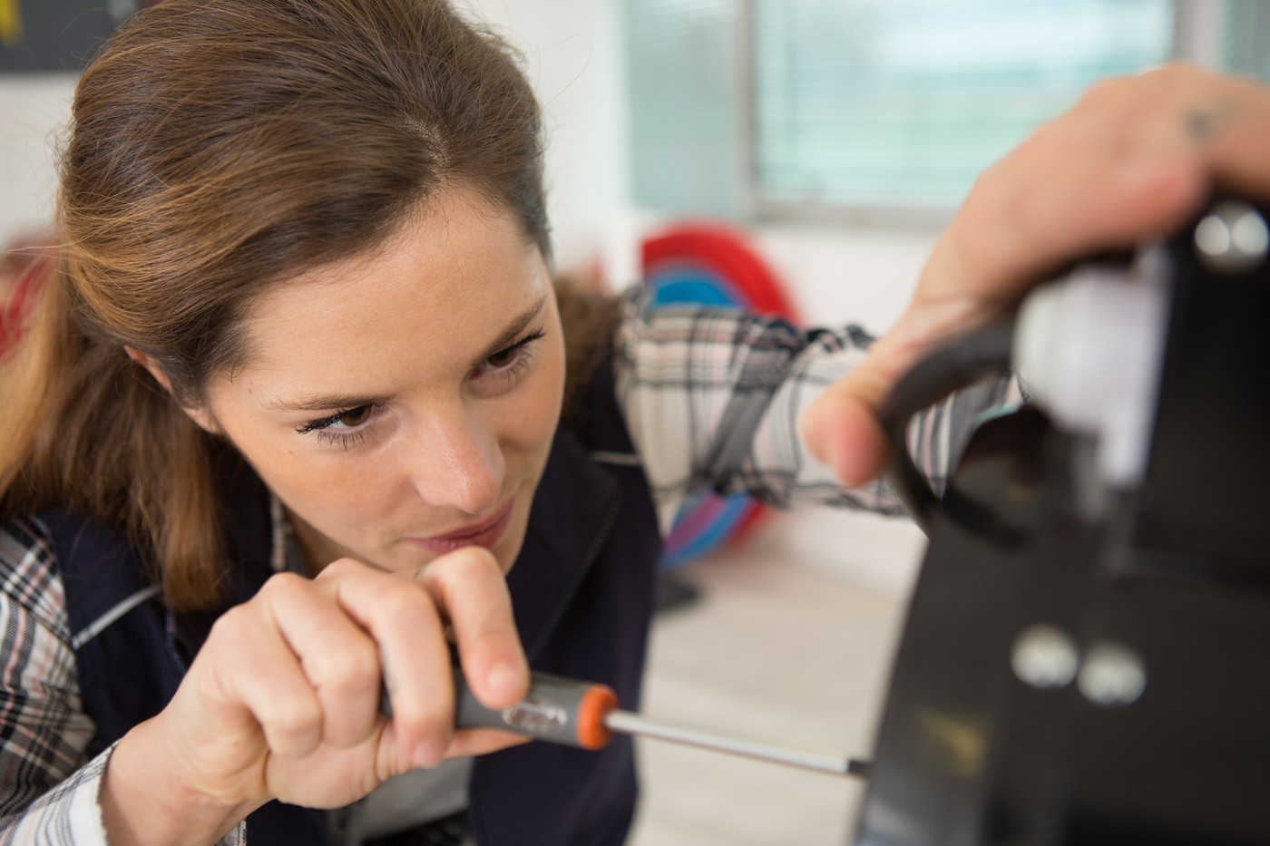 portrait of female engineer using a screwdriver