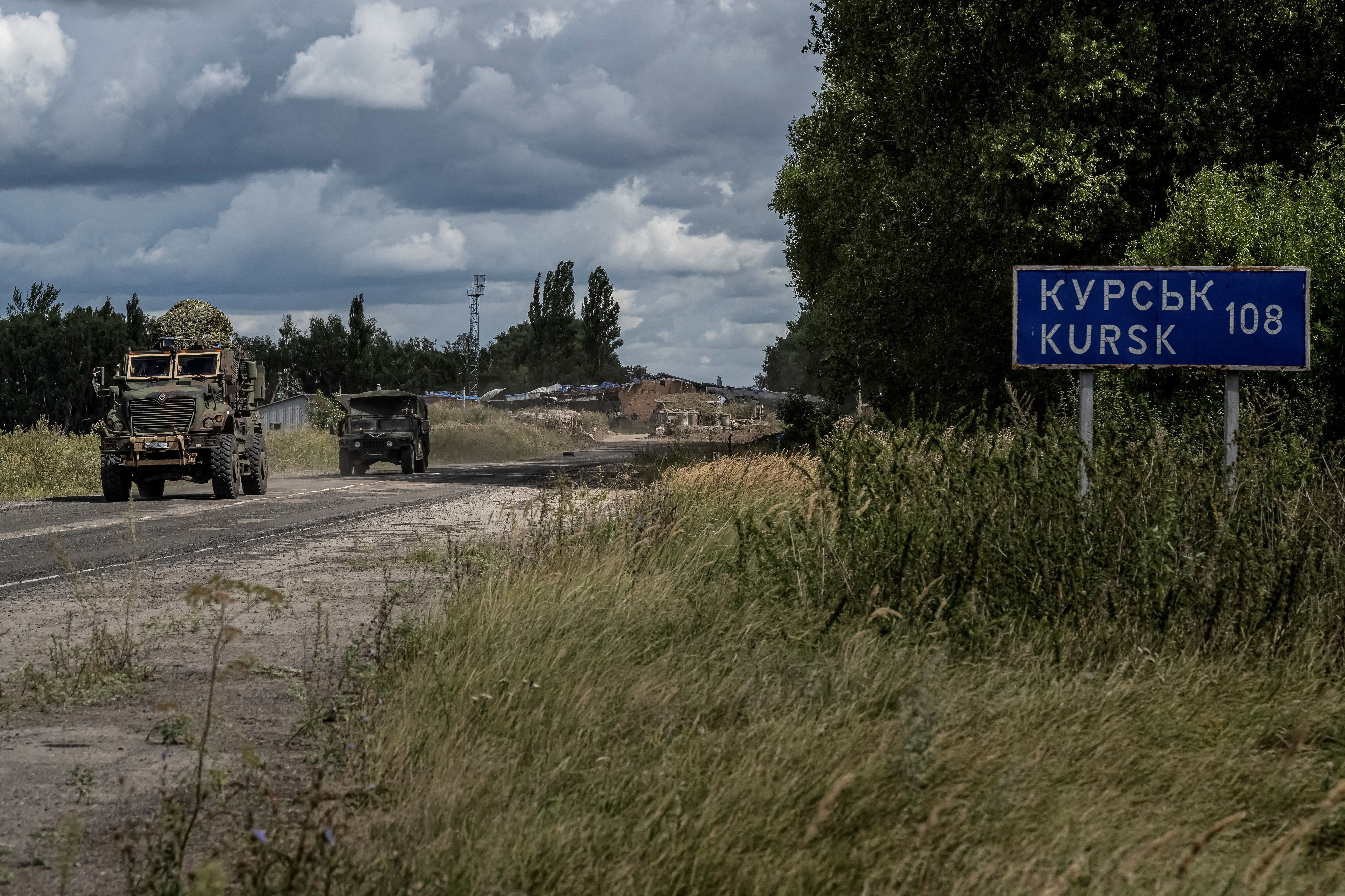 FILE PHOTO: Ukrainian servicemen ride military vehicles from a crossing point at the border with Russia in Sumy region
