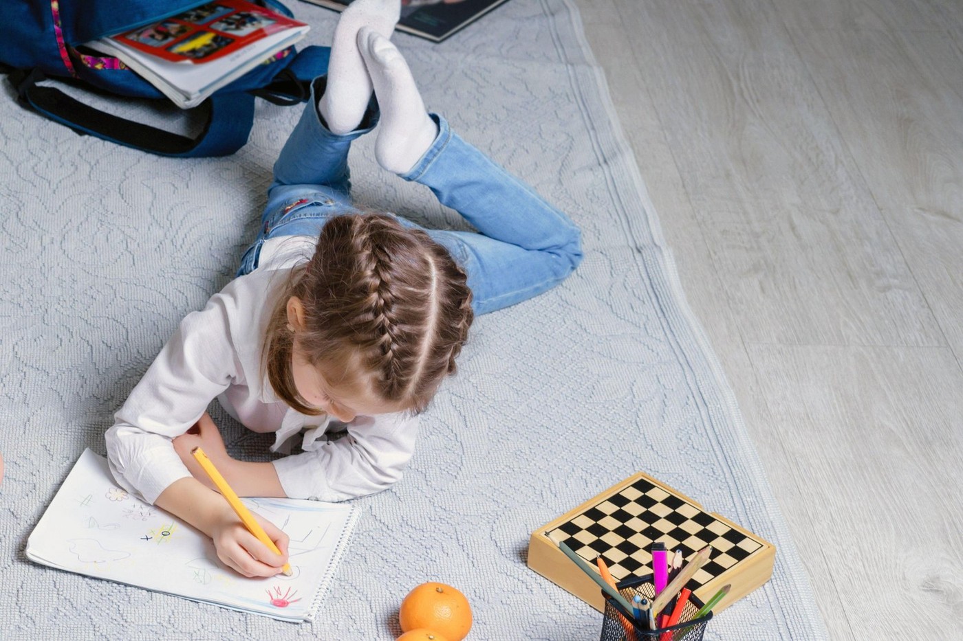 Cute little girl is drawing on a floor