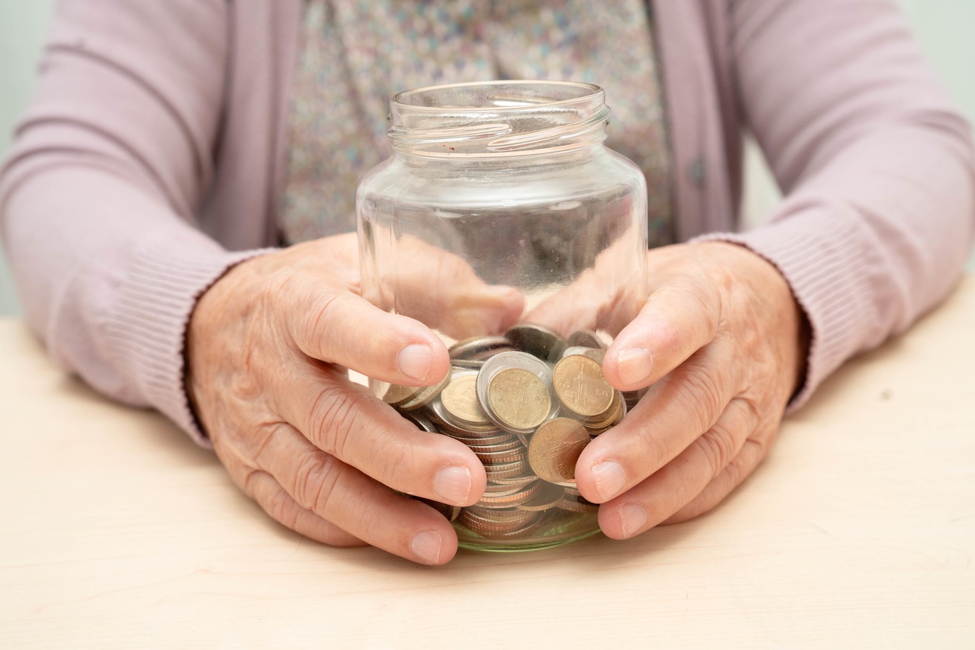 Retired Asian elderly woman counting coins money and worry about