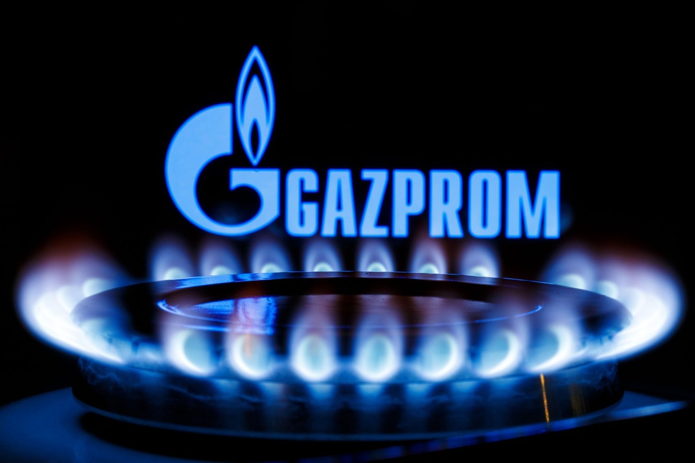 Gazprom is a Russian majority state-owned multinational energy corporation. Gas burner on the background of the Gazprom logo.