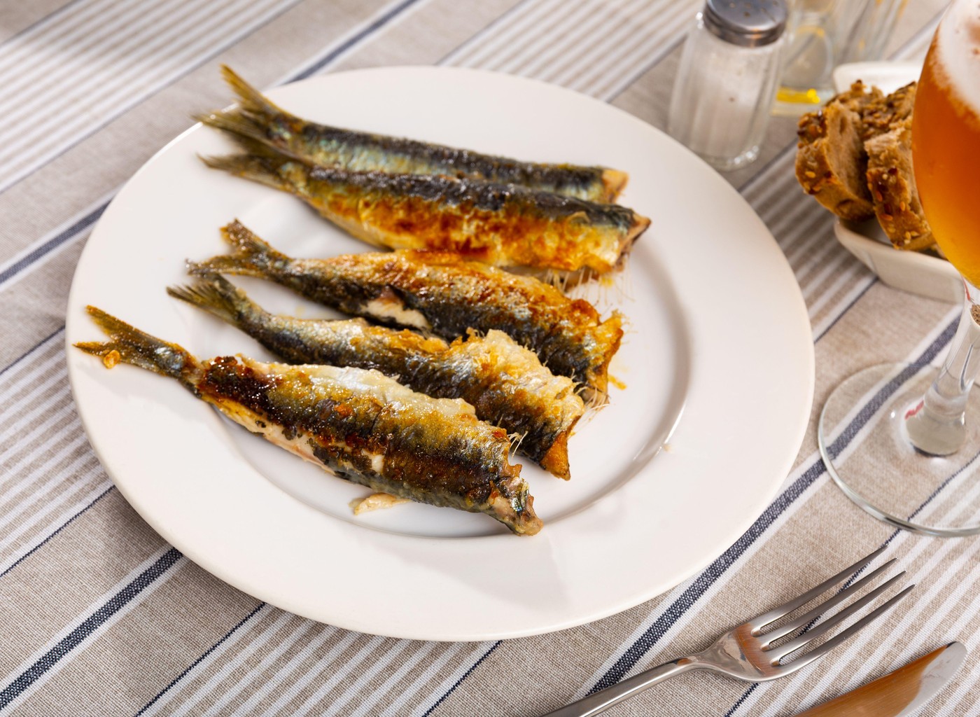 Grilled sardines served with bread and glass of beer