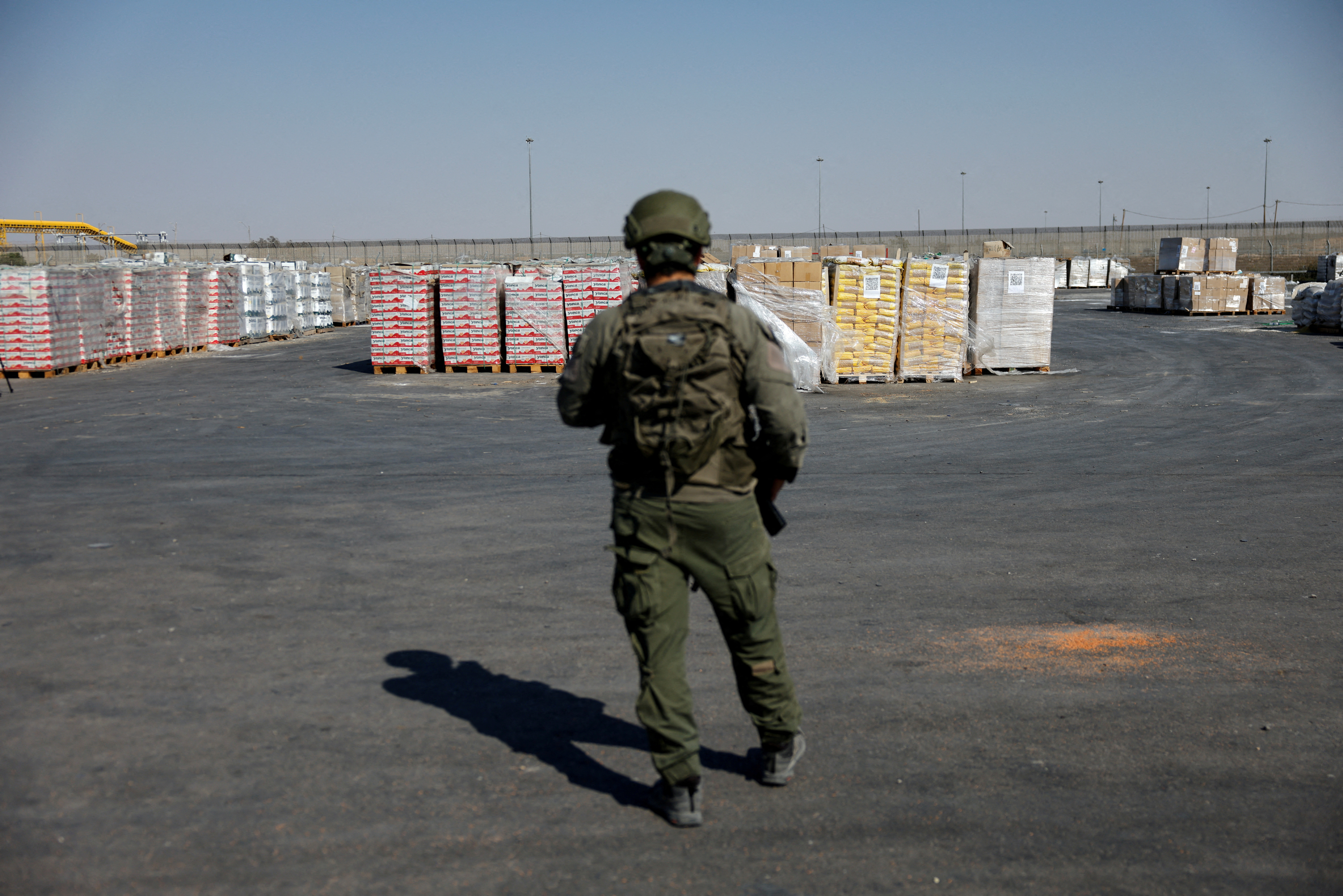 Izraelski vojak straži humanitarno pomoč za Gazo ob meji z enklavo