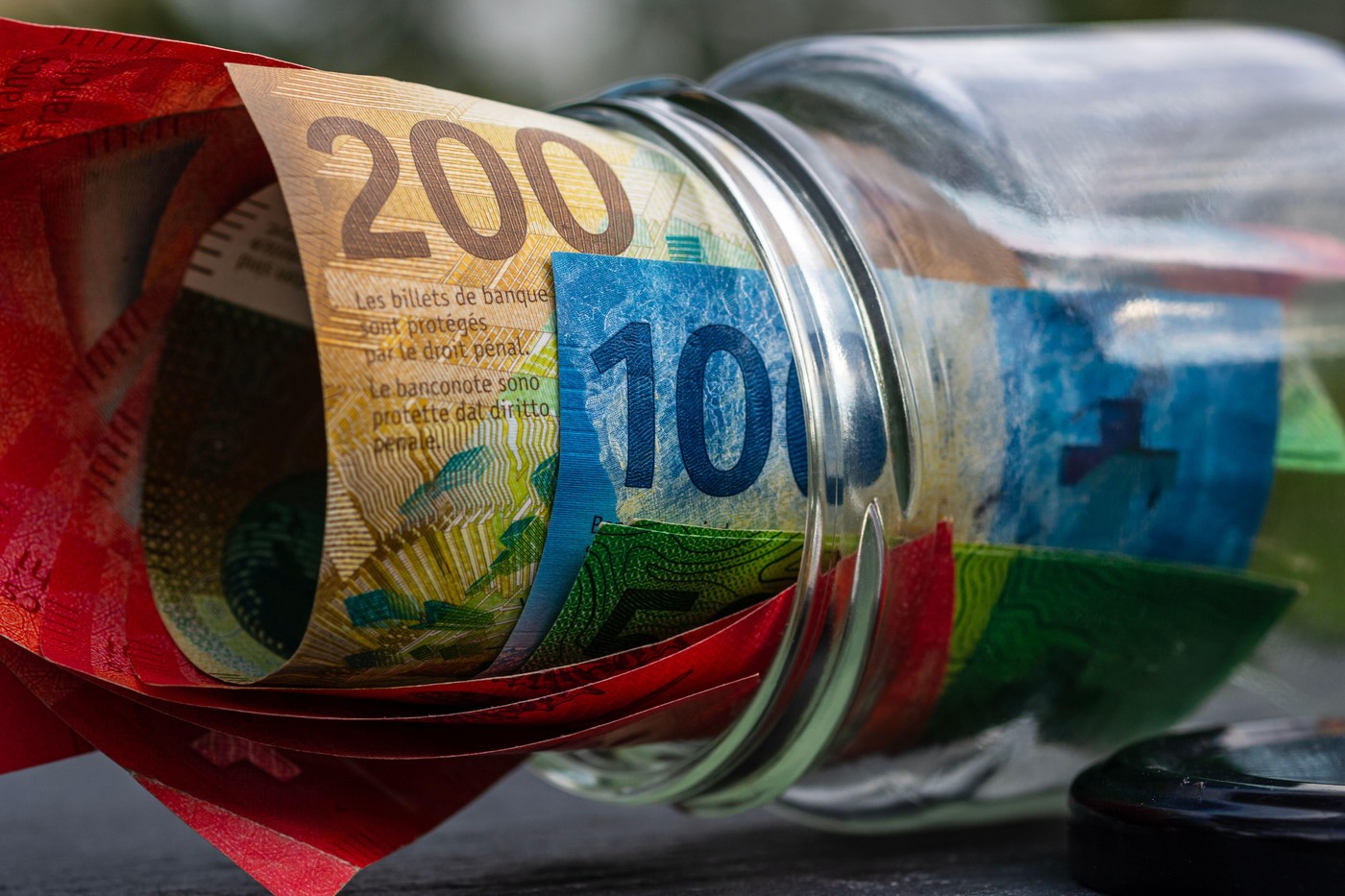 švicarski franki bankovci denar v kozarcu