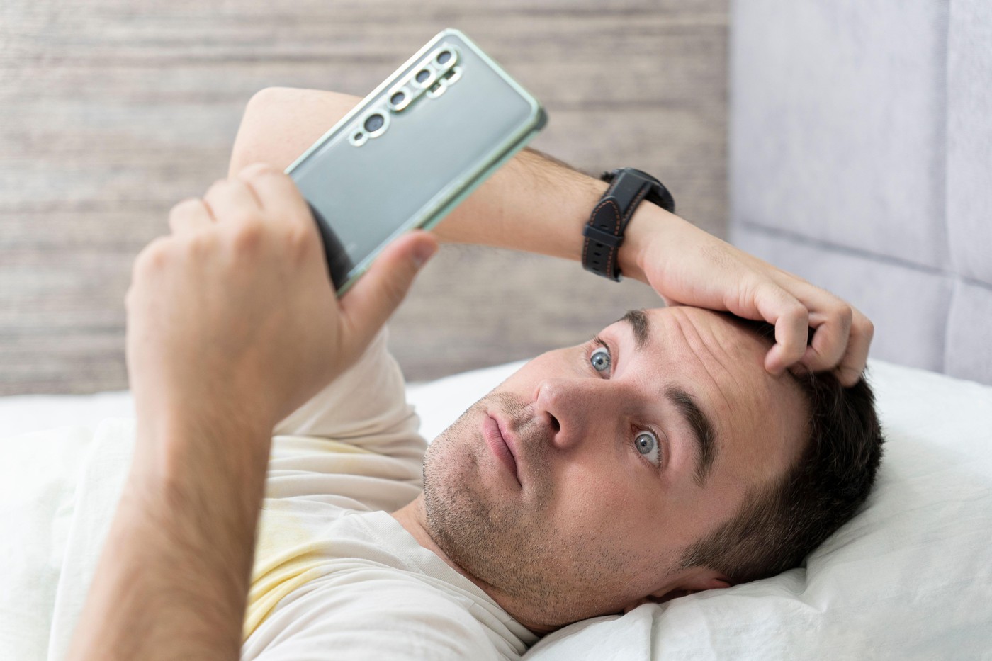 moški v postelji presenečen dobi sporočilo alarm mobilni telefon