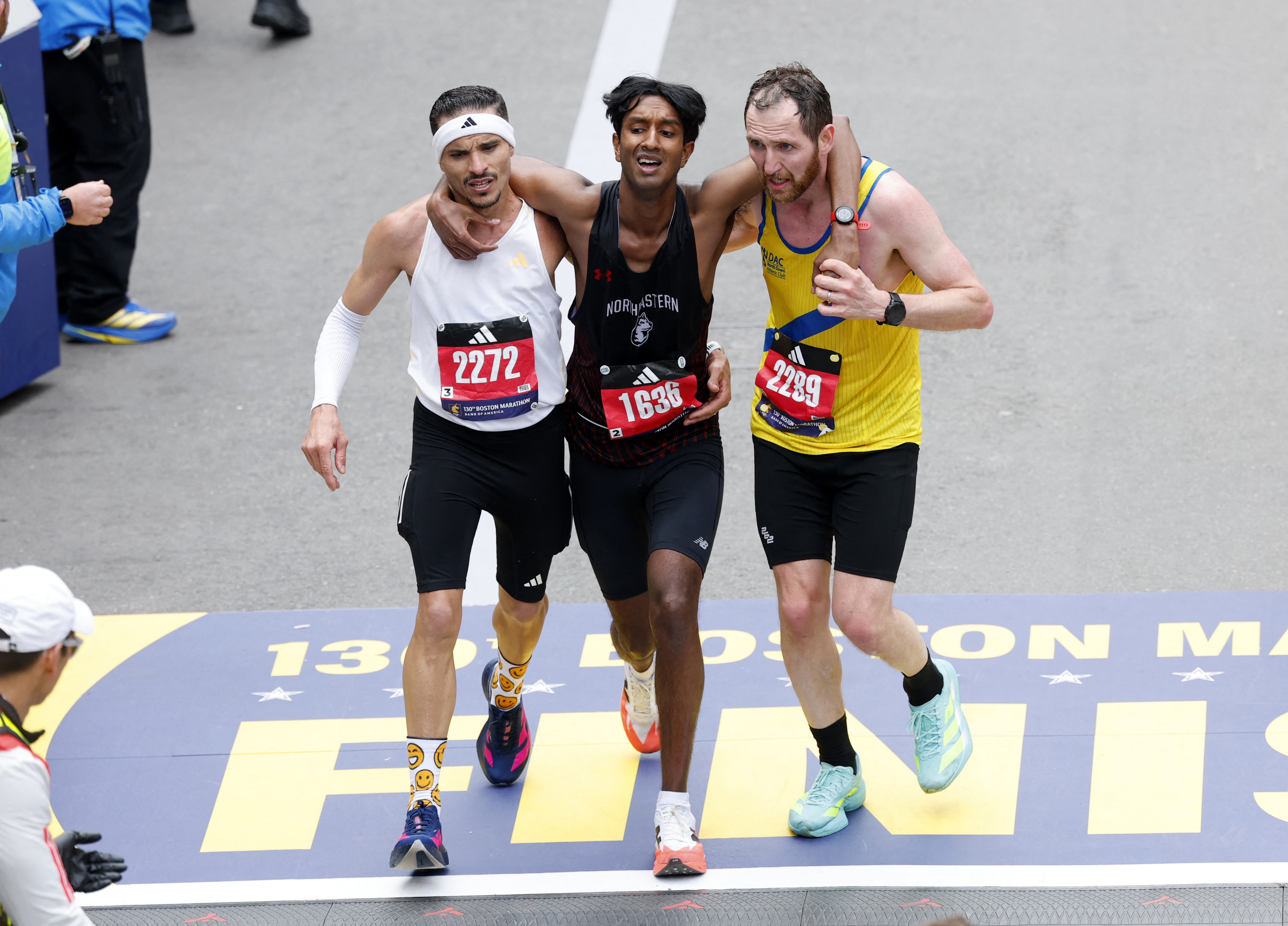 Athletics - Boston Marathon - Boston, Massachusetts, U.S. - April 20, 2026 Robson De Oliveira, Ajay Haridasse and Aaron Beggs cross the finish line in the marathon REUTERS/Cj Gunther