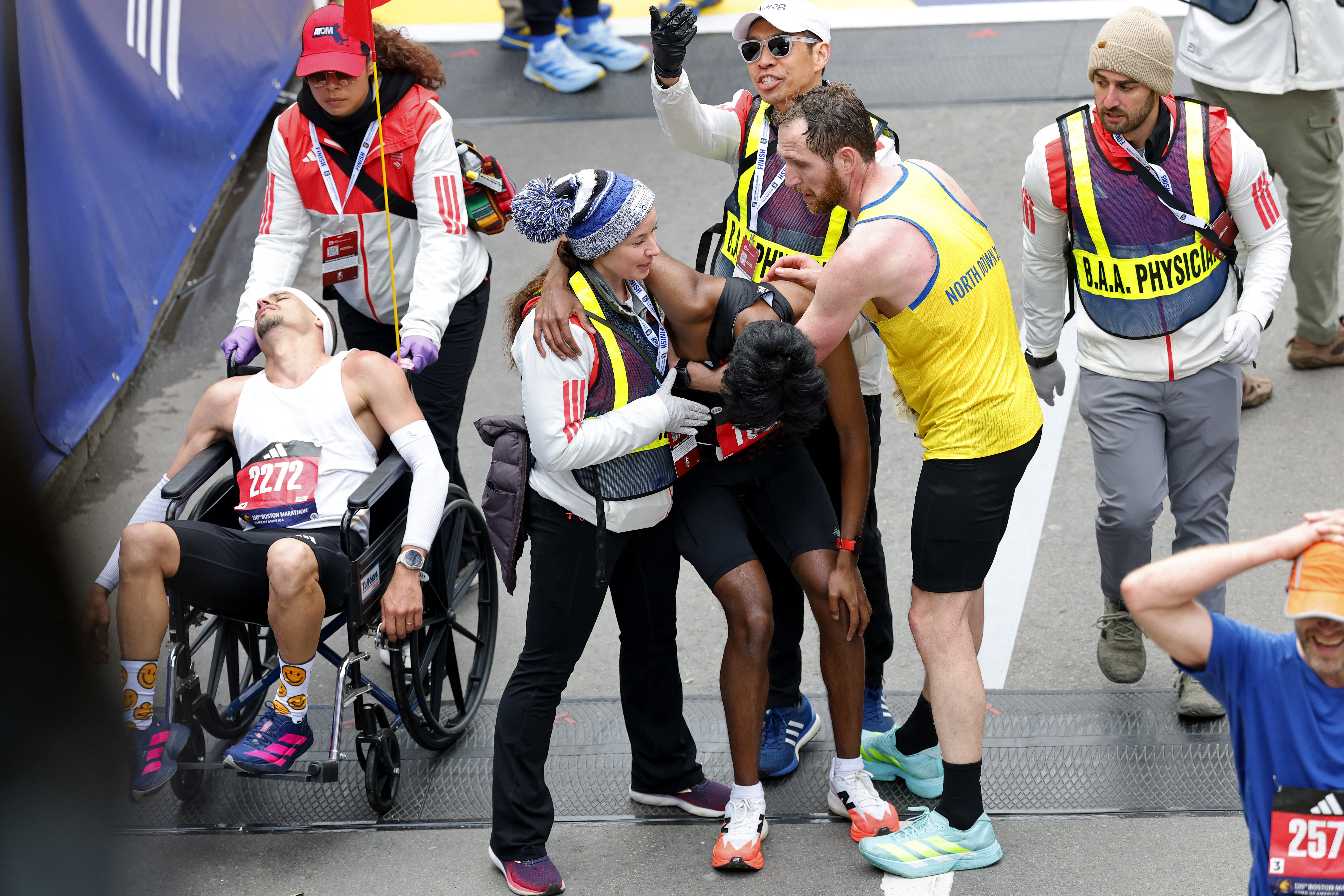Athletics - Boston Marathon - Boston, Massachusetts, U.S. - April 20, 2026 Robson De Oliveira and Ajay Haridasse receive medical attention after crossing the finish line in the marathon REUTERS/Cj Gunther