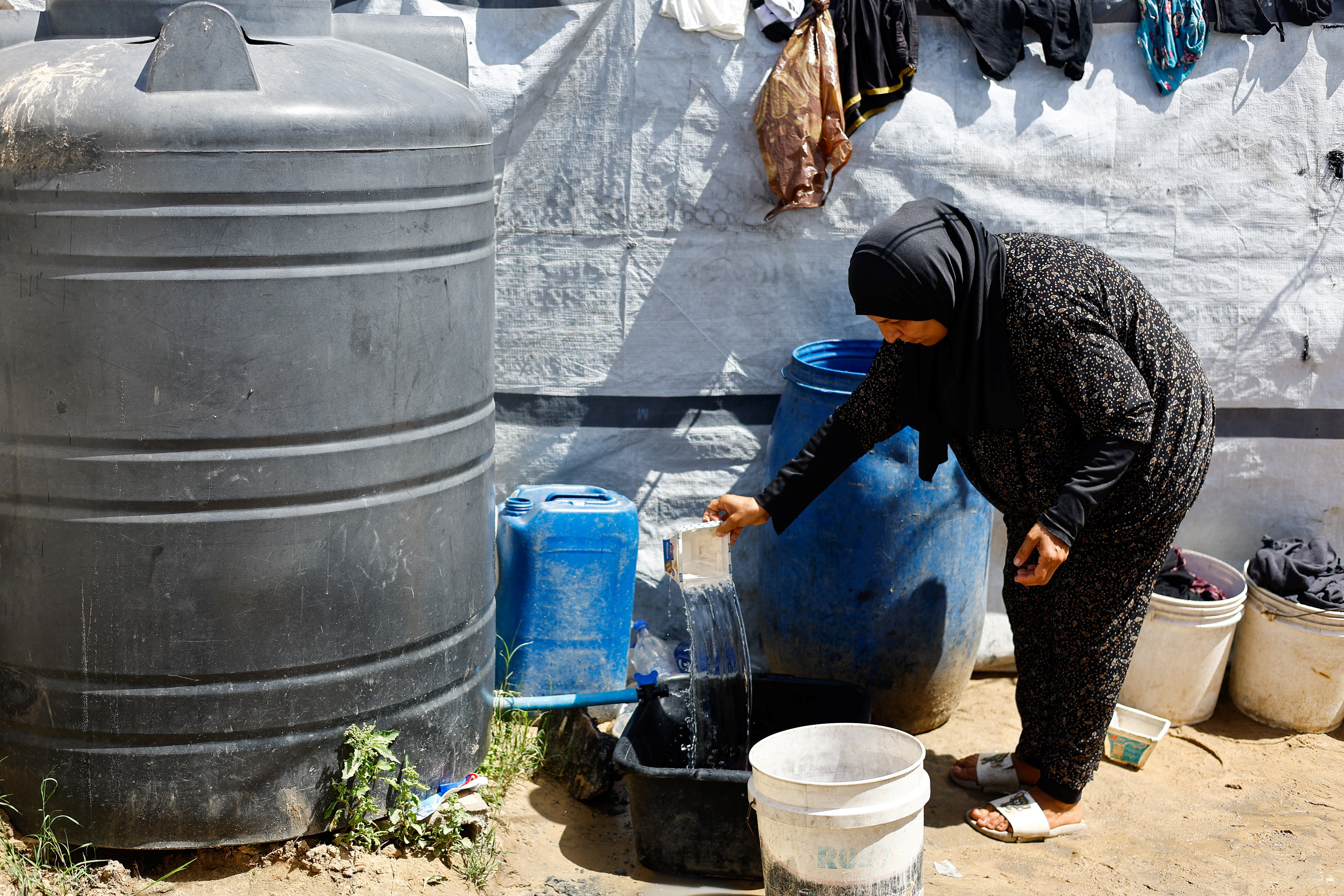 Ženska v Gazi naliva vodo