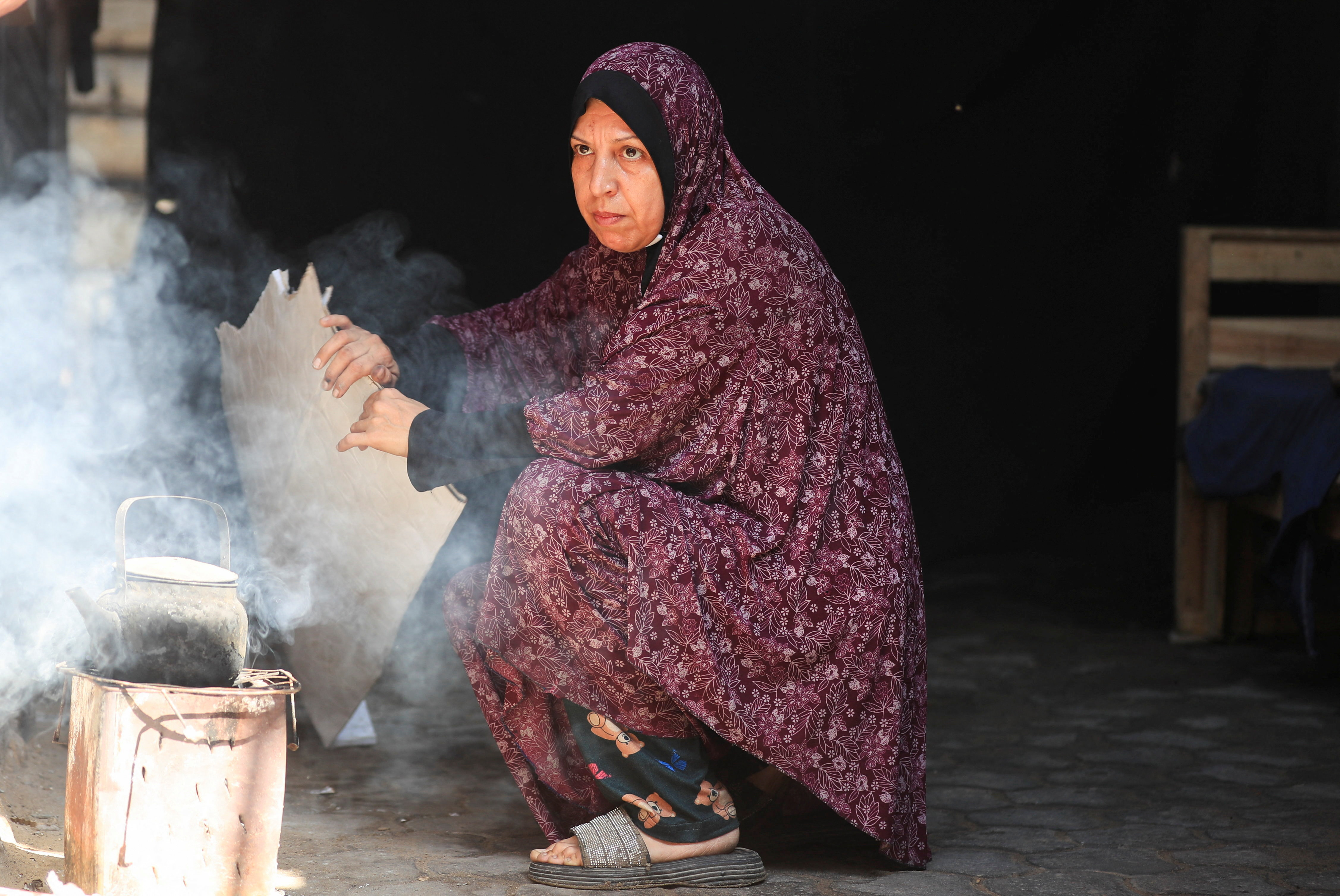 Palestinka v mestu Gaza kuha in pripravlja hrano