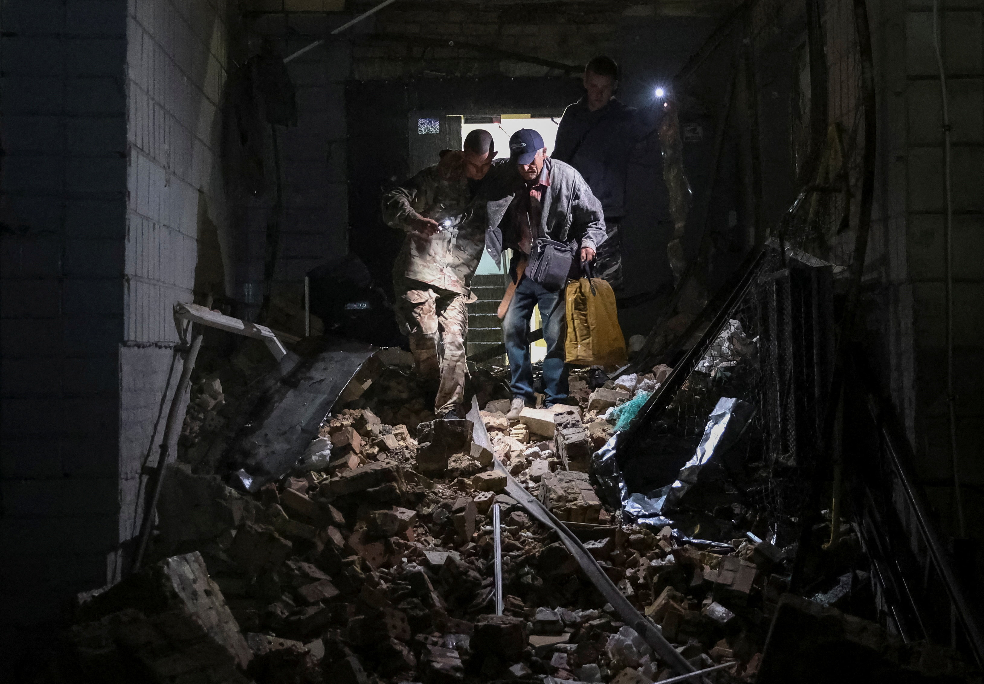 Prostovoljci rešujejo ljudi izpod ruševin po ruskem raketnem napadu na Kijev