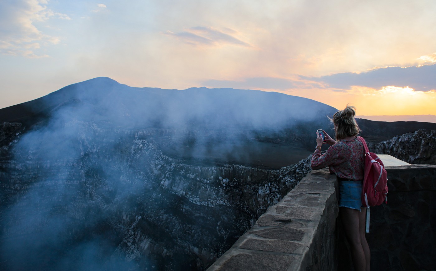turistka fotografira vulkanski krater Santiago, imenovan tudi Boca de Infierno, žrelo pekla na vulkanu Masaya v Nikaragvi