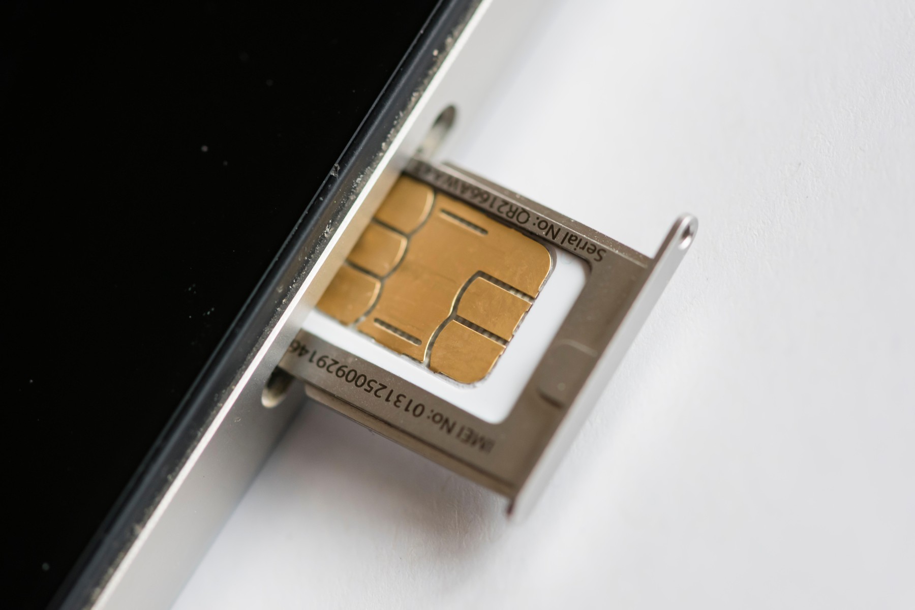 A SIM-card is inserted into an Apple iphone 4 smartphone. The SIM ("Subscriber Identity Module") card holds security keys to identify and authenticate mobile telephony data.,Image: 236158279, License: Rights-managed, Restrictions: , Model Release: no