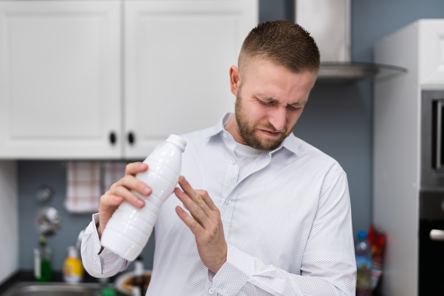 moški v kuhinji odprl pokvarjeno mleko slab vonj smrad