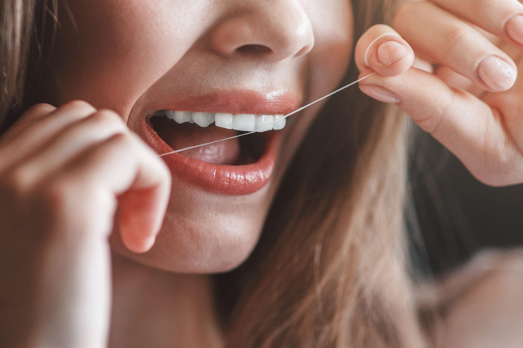 Ženska uporablja zobno nitko