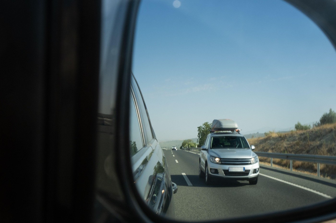 A rearview of a SUV car with the reflection of a van that has a luggage carrier or roof box. Concept of road trip, driving, overtaking, road safety and rolling traffic,Image: 982046088, License: Royalty-free, Restrictions: , Model Release: no