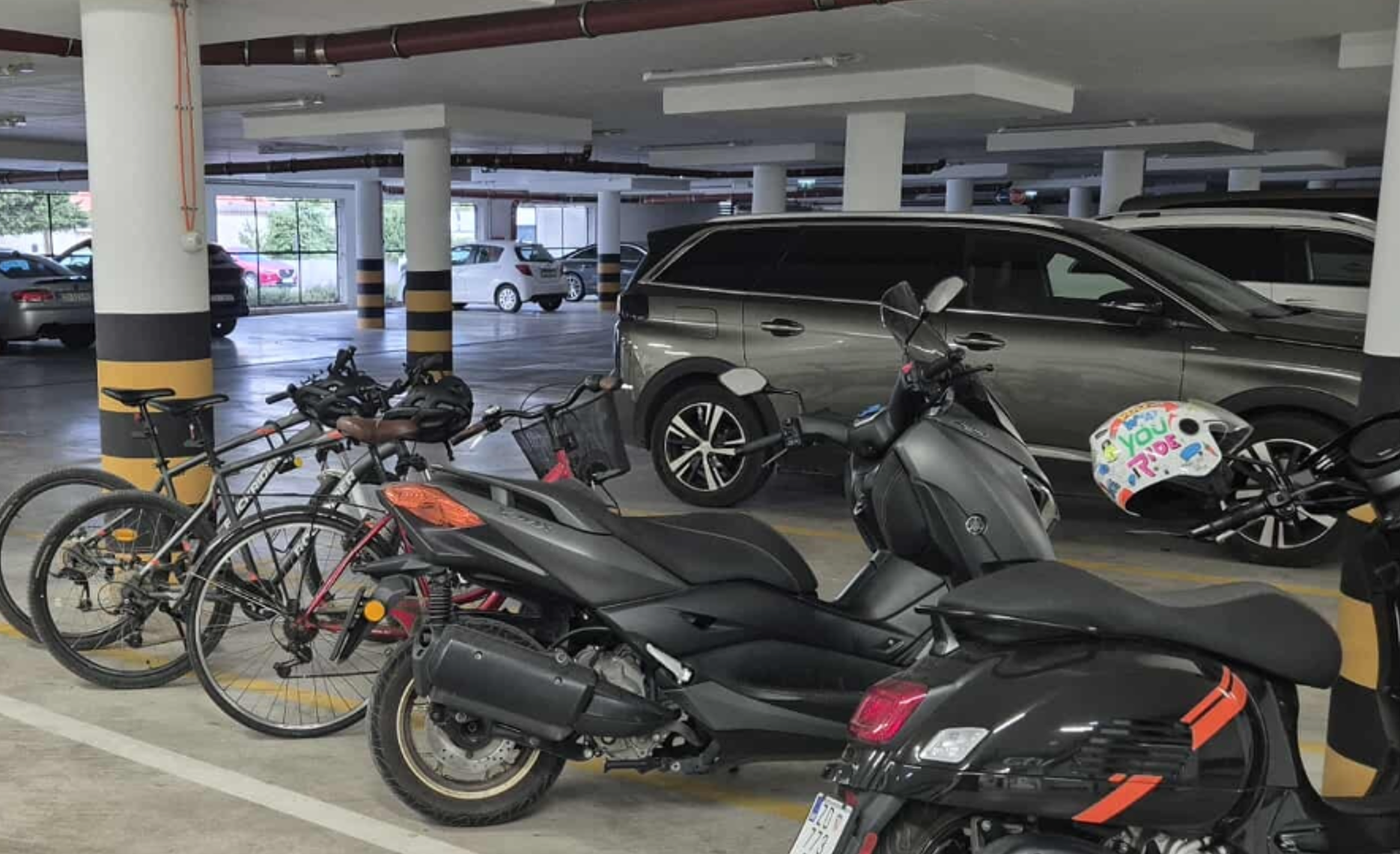 garažna hiša v Dalmaciji s parkiranimi vozili, motorji in kolesi