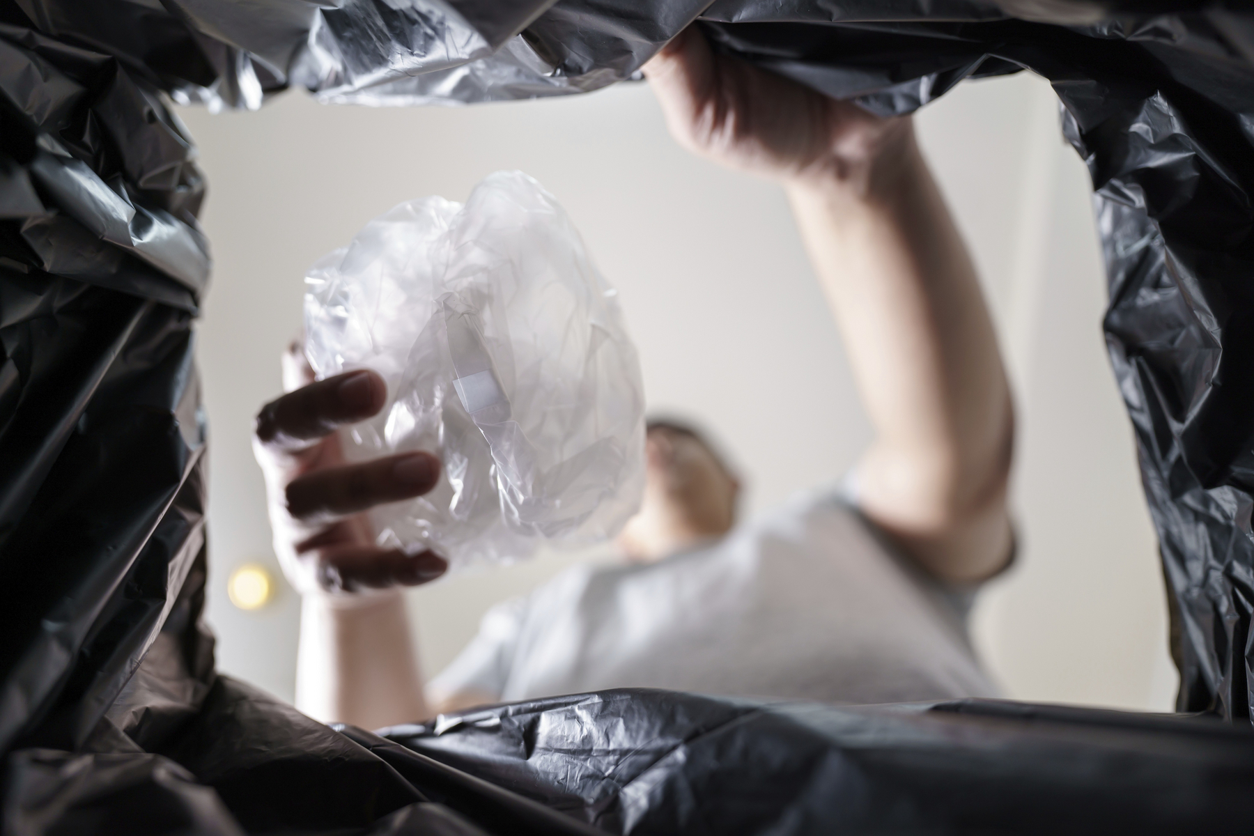 Image from inside yellow recycling bag of man throwing empty plastic bottle in recycling bin Home recycle eco green zero concept,Image: 1022363735, License: Royalty-free, Restrictions: , Model Release: yes