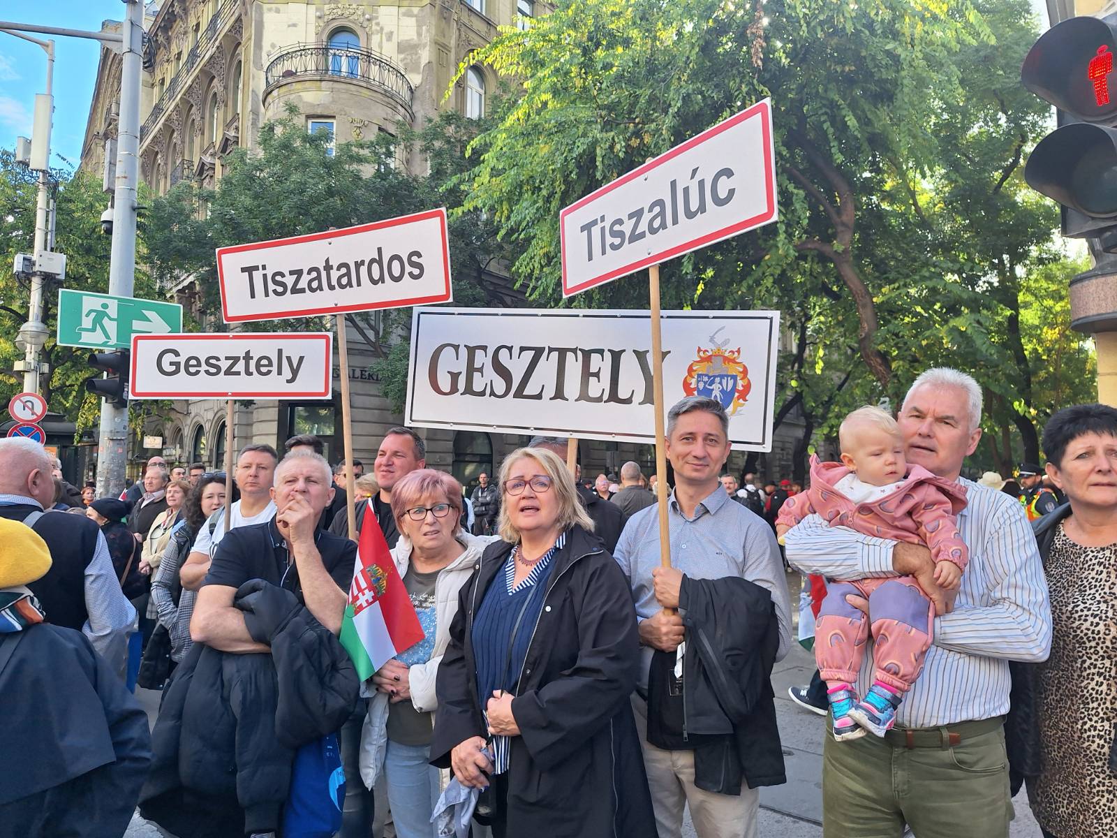 Ljudje na shodu držijo transparente z imeni krajev, od koder prihajajo